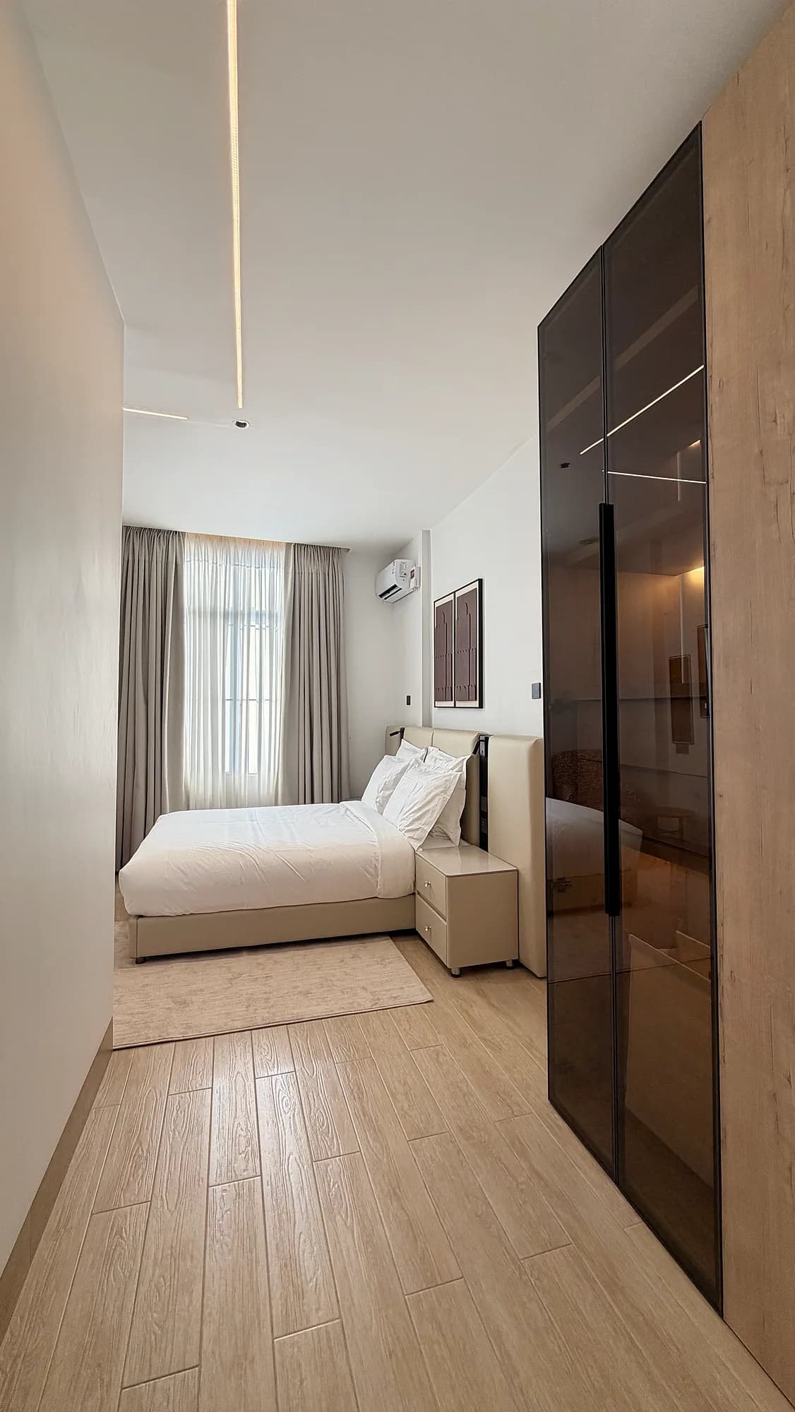 2BHK Suite bedroom with smoked-glass wardrobe, Kigo Kampala